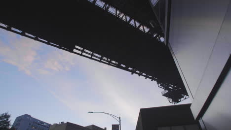 Tilting-Gimbal-shot-of-the-underside-of-the-brooklyn-bridge-on-the-streets-of-dumbo