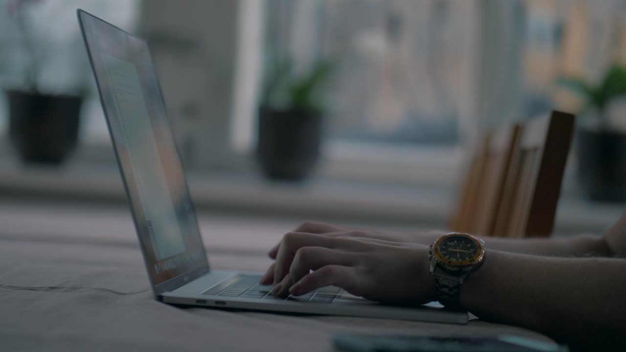 Man writing fast on a laptop while working from home