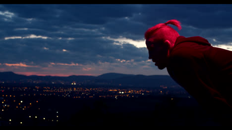 man with pink hair at sunset over the city