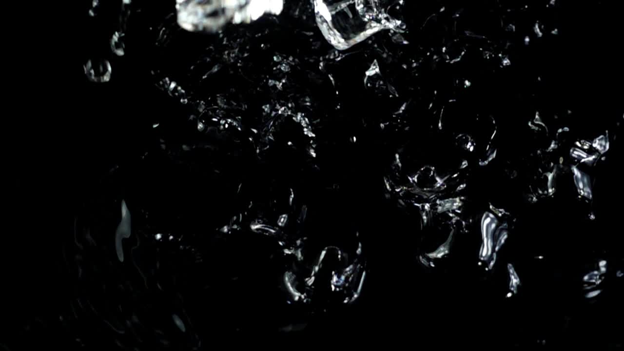 Falling of cubes of ice on a black background. Slow motion