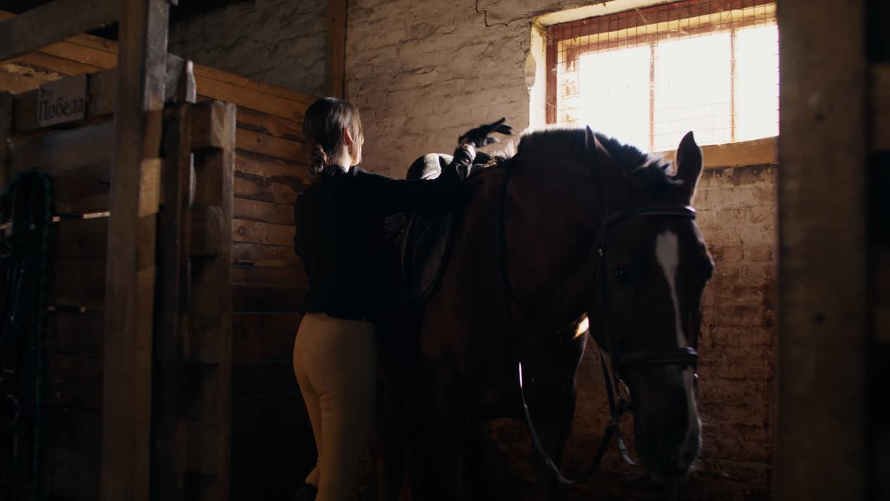 Donna che prepara il cavallo in una stalla