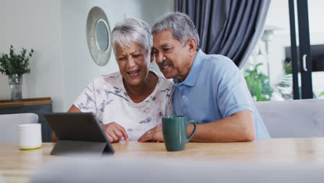 Feliz-Pareja-Birracial-Senior-Riendo-Y-Usando-Tableta