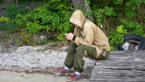 hombre sentado en un muelle de madera en un bosque junto a la playa