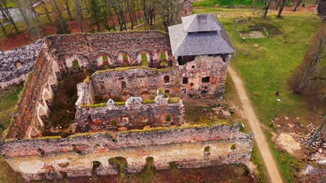 medieval castle ruins and town buildings in aerial fly over drone view