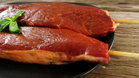 skewed raw meat garnished with basil