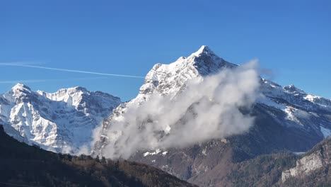 Toma-Orbital-De-Montañas-Nevadas-Con-Hermosas-Nubes-En-Amden,-Suiza