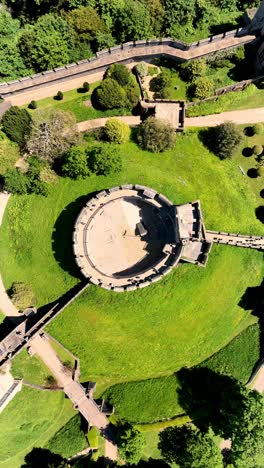 ascending aerial drone footage of castle moat and gardens