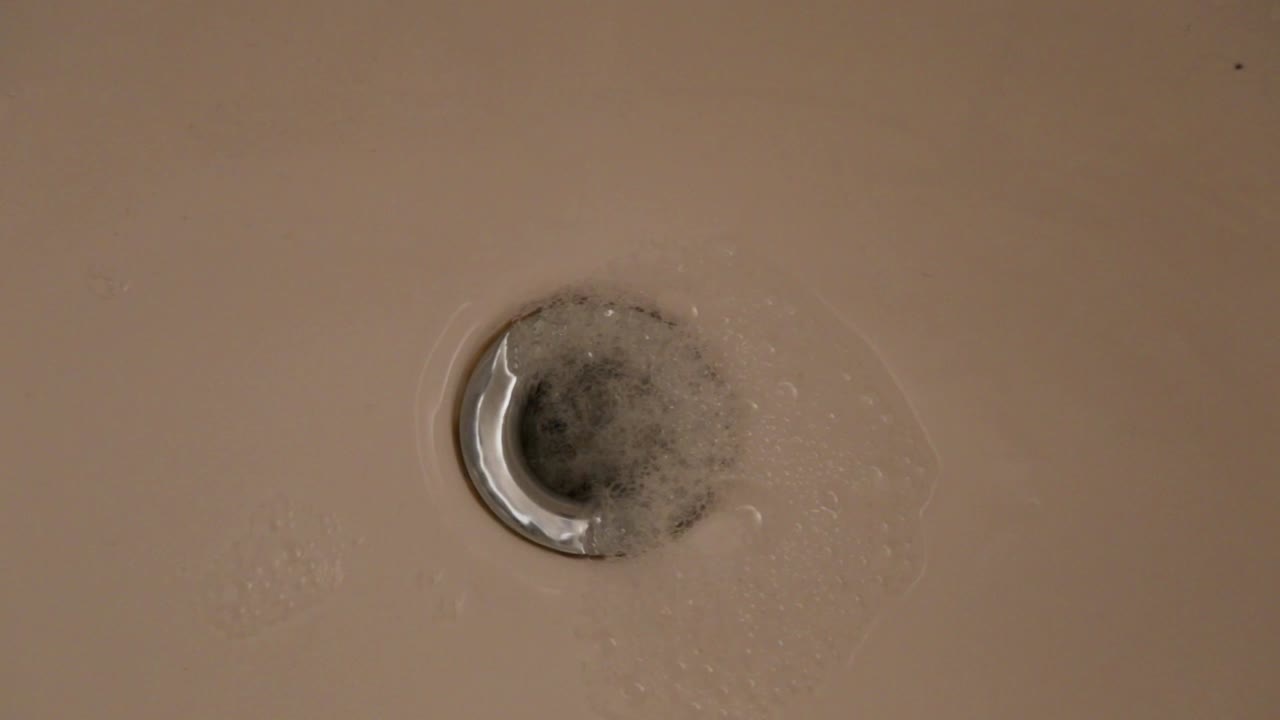 agua y burbujas bajando por el desagüe