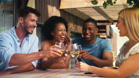 Gruppe-Lächelnder-Multikultureller-Freunde-Im-Freien-Zu-Hause,-Die-Gemeinsam-Wein-Trinken