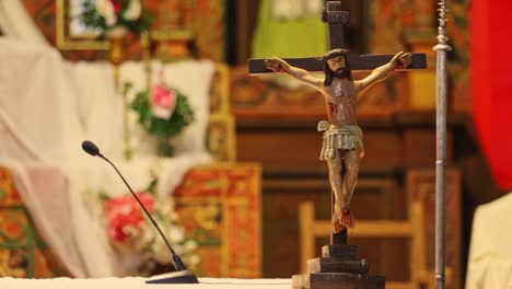 primer plano de un pequeño muñeco de madera de jesucristo guardado en la iglesia cerca del micrófono
