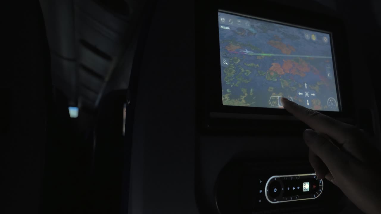 밤 비행 중 좌석 모니터를 사용하는 여성