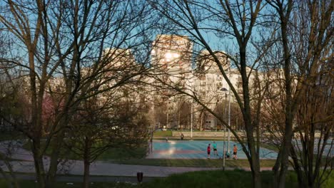 aerial reveal shot flying through some trees to show an athletic park in zagreb, croatia