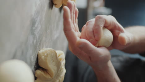 hands of baker forming dough ball