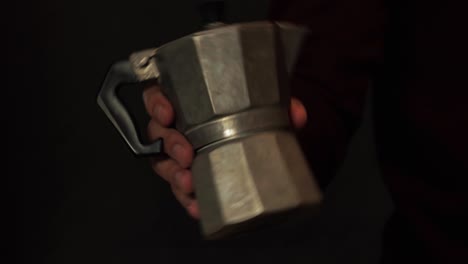 hand holding a classic moka pot, capturing the simplicity of brewing rich espresso at home. this vintage coffee maker is perfect for coffee lovers and home baristas alike.