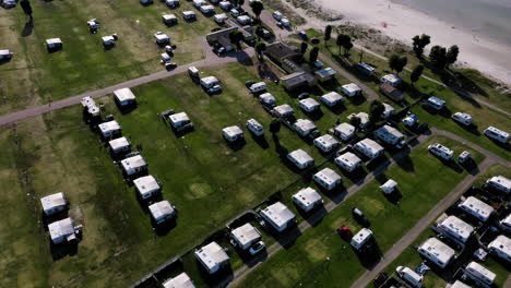 Viele-Dicht-Geparkte-Wohnwagen,-Die-Auf-Dem-Campingplatz-Campen,-Genießen-Urlaub-Urlaub-Pause-Spielende-Kinder-Spielen-Sandstrand-Antenne-Drohne-Vögel-Sehen-Wellen-Ufer-Sommergefühl-Glücklich-Entspannt-Europäisch-Reise-Spaß