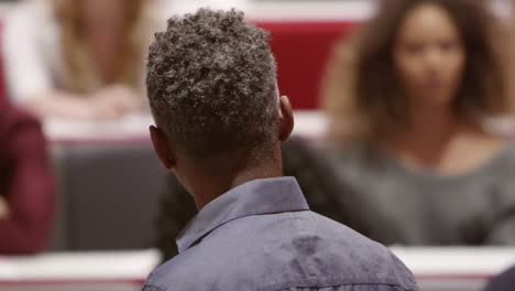 Close-up-back-view-of-male-teacher-lecturing-university-students,-shot-on-R3D