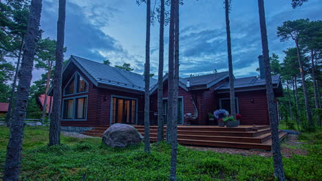 Shot-of-a-country-house-surrounded-by-trees-during-evening-time-as-it-gradually-darkens-in-timelapse