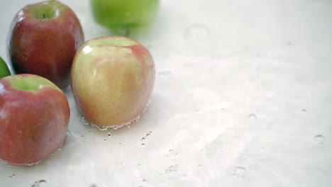 slomo de manzanas en agua sobre fondo blanco