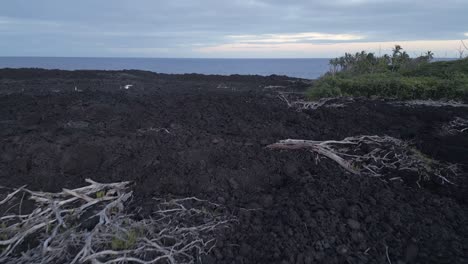 low flyover: black volcanic lava flow ash, car drives on new road