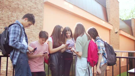 las adolescentes se divierten y conversan usando sus teléfonos móviles