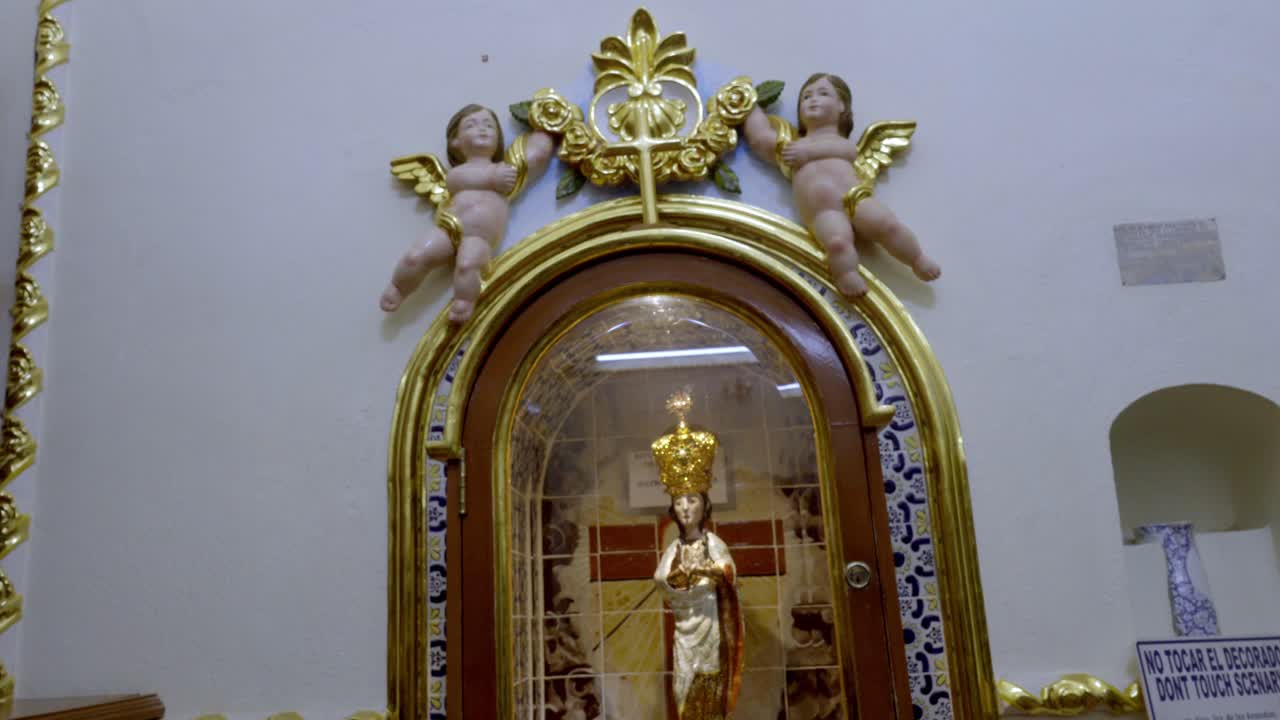 Statua di un santo in una cornice dorata con cherubini, atmosfera di festa