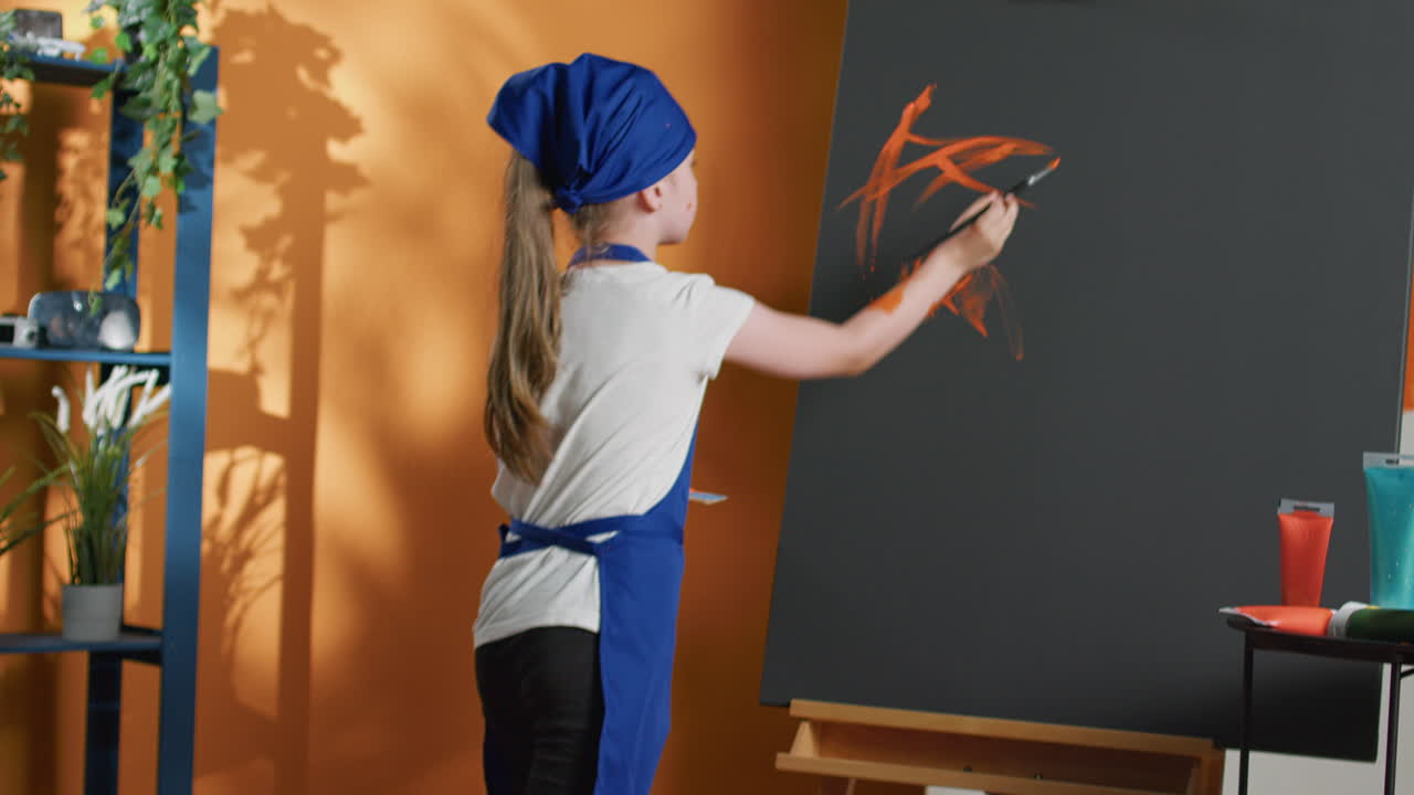 Girl painting on canvas in art studio