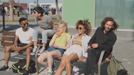 lounging diverse friends on bench in sunshine