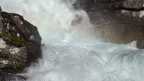 Fresh-clear-mountain-water-from-Straume-River-in-Vaksdal-Norway---Closeup-of-water-stream-splashing-in-the-sunlight-and-with-a-glimpse-of-rainbow-colors-in-middle