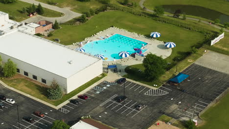 complejo de acondicionamiento físico y bienestar con piscina, gimnasio, estacionamiento público y cancha