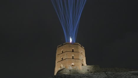 luces láser que iluminan el cielo nocturno desde un castillo medieval