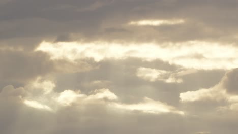 A-pan-down-shot-of-sun-rays-coming-through-the-clouds-descending-above-a-tropical-rainforest-during-sunset