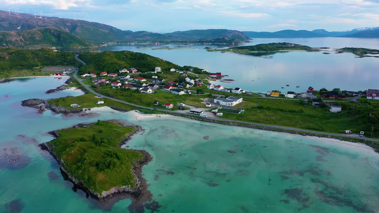 Drone shot following a RV driving at turquoise sea, on the coast of the Barents sea, in the village of Sommaroy islands, summer evening, in Troms, Norway - tracking, aerial view