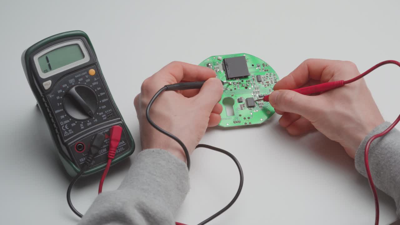 멀티미터로 결함이 있는 회로 기판을 진단하는 남자