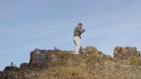 hombre practicando artes marciales en una montaña