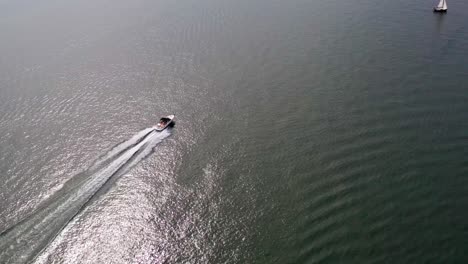 aerial drone footage following motorboats on lake biel and showing off the blue waters and gorgeous scenerty