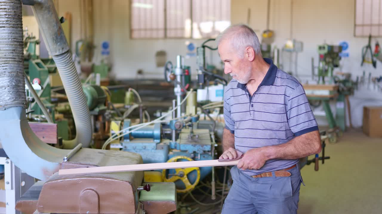 Abile falegname che leviga un pezzo di legno nel suo laboratorio