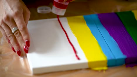 a woman painting colorful stripes on a canvas