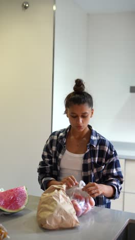 mujer preparando frutas y verduras en una cocina
