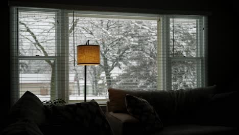 wide angle view out of a living room window during a snowstorm in the winter