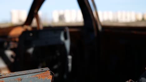 dentro de un coche oxidado antiguo con las afueras de la ciudad en la distancia