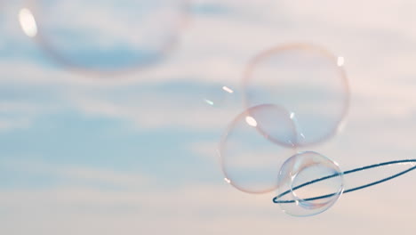 close up woman blowing bubbles floating on beach