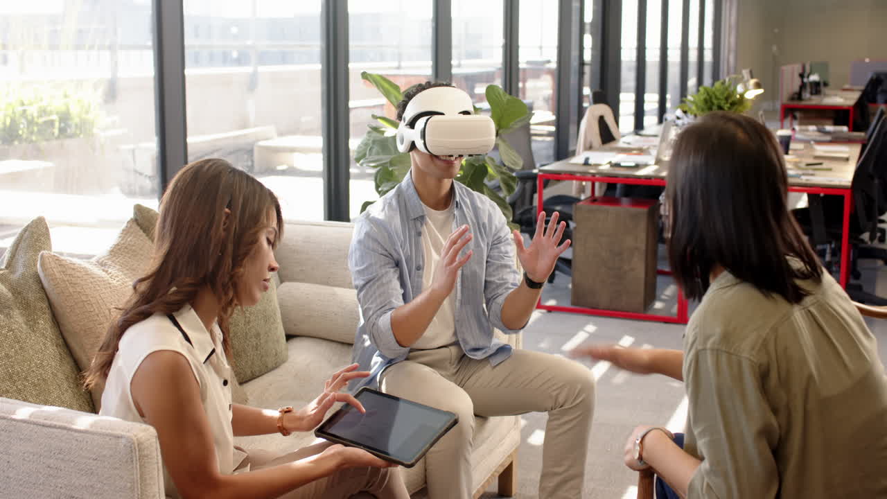 Using VR headset, man discussing interior design with multiracial colleagues using tablet in office
