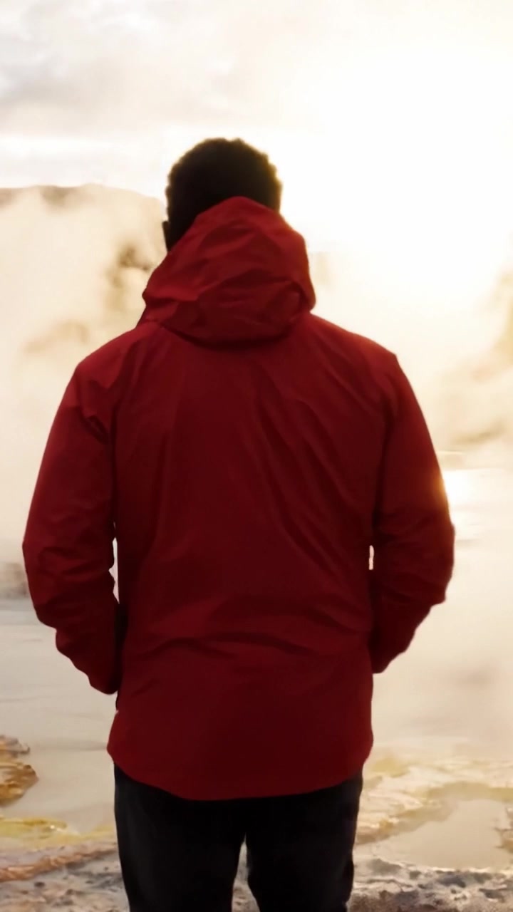 A Serene Moment of Reflection: A Person in Red Jacket Silently Observing a Natural Hot Spring at Sunrise Amidst Misty Conditions