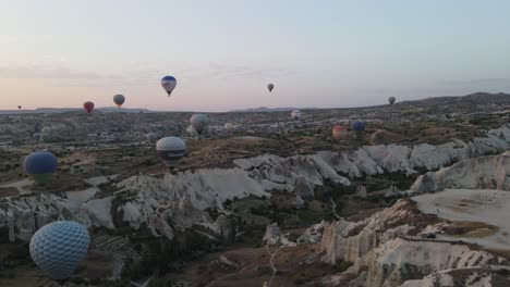 Flying-balloon-image-taken-by-drone,-flying-balloons-in-the-valley-of-Nevsehir-Cappadocia,-very-popular-tourism-of-hot-air-balloons