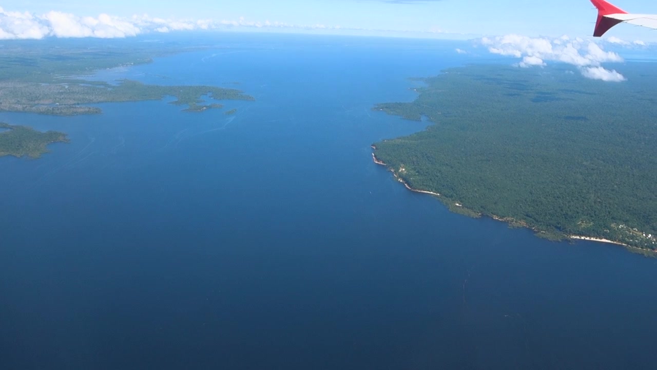 Filmisk luftoptagelse af den enorme Amazonas regnskov og den dybblå Negro-flod i Brasilien, der viser omfanget af det tropiske økosystem.