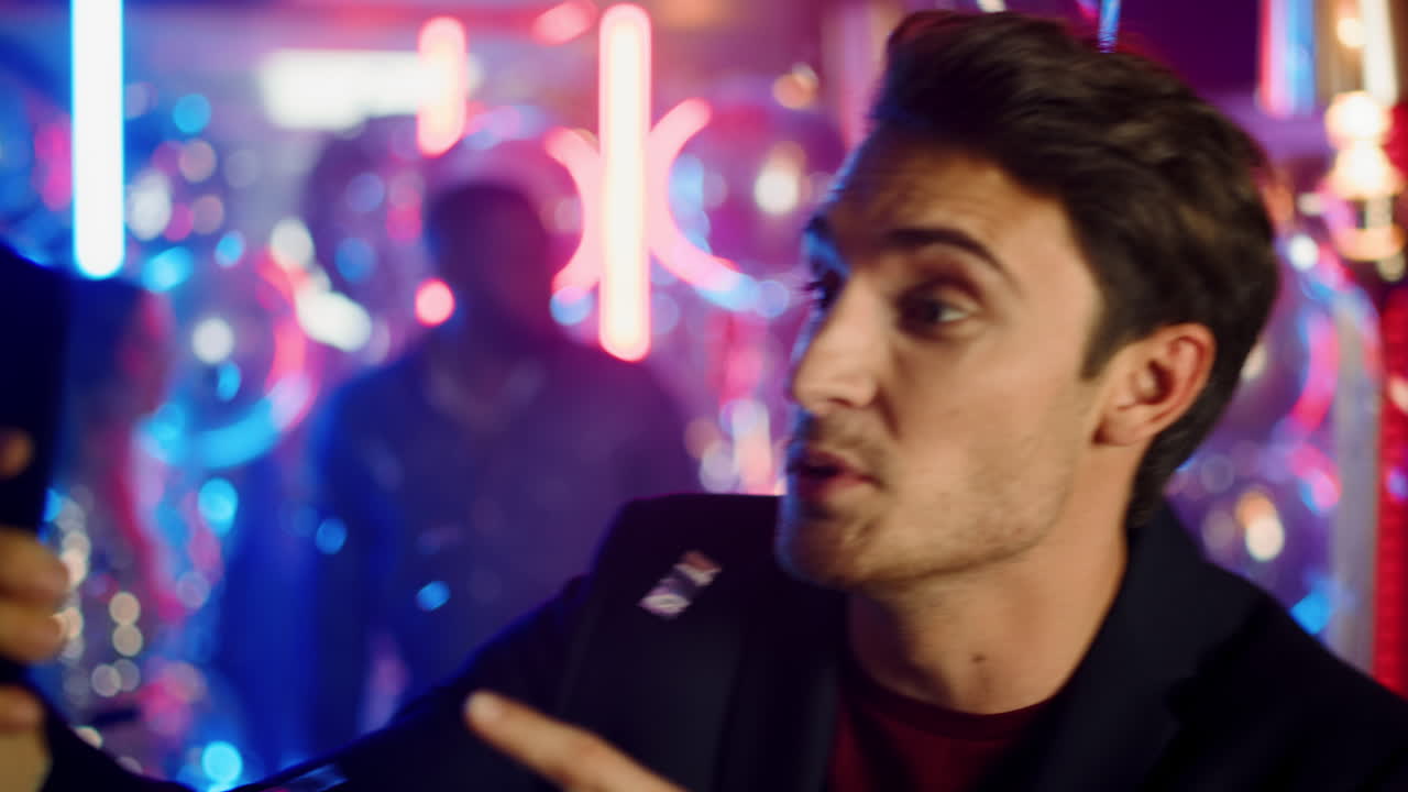 hombre emocional haciendo una videollamada en una fiesta. tipo sincero usando el teléfono en un club nocturno