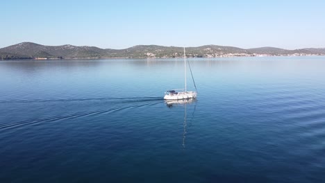 sailboat floats along the coast of biograd na moru and tkon, dalmatia, croatia - aerial drone view