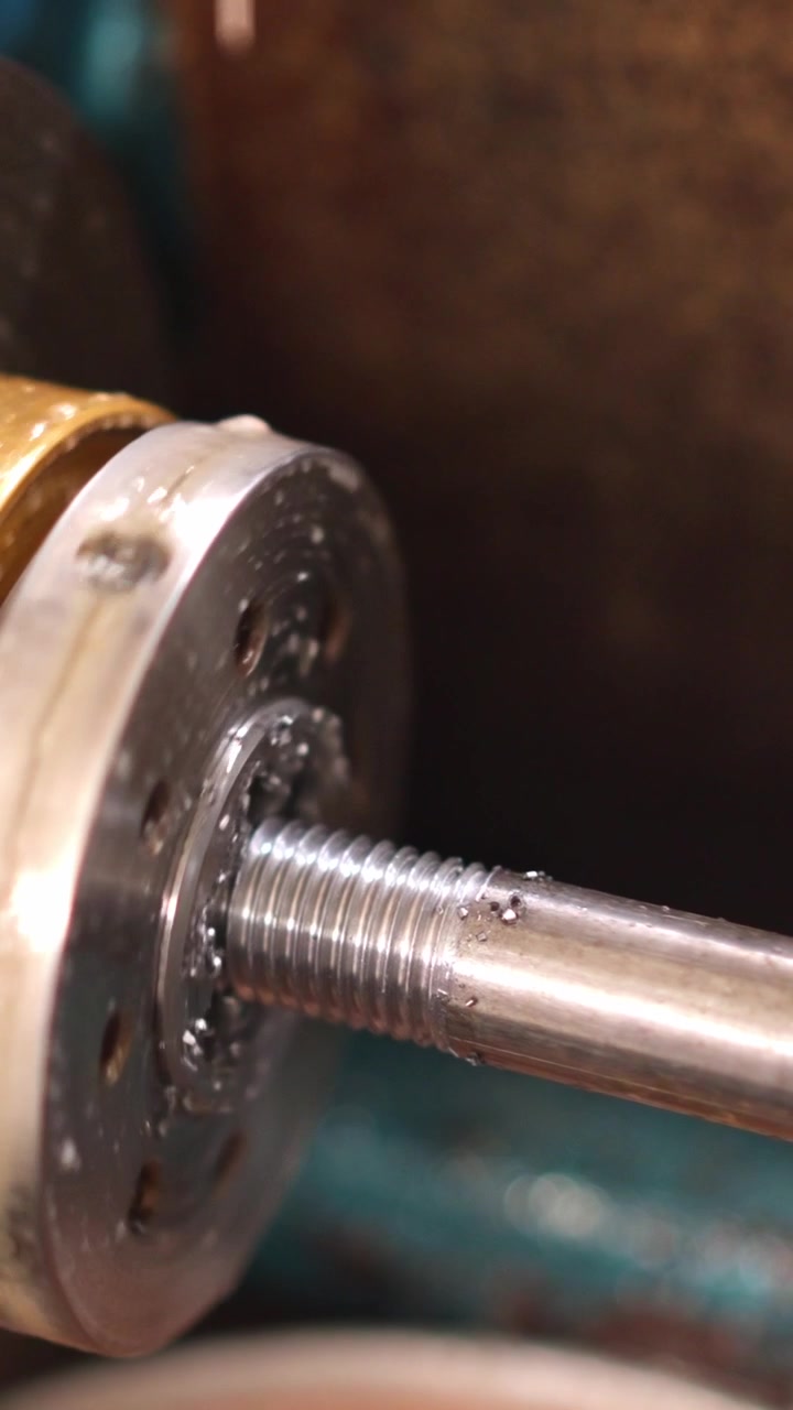 Close-up of a Metal Rod Being Threaded by a Machine