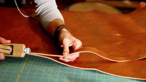 close-up of craftswoman cutting leather