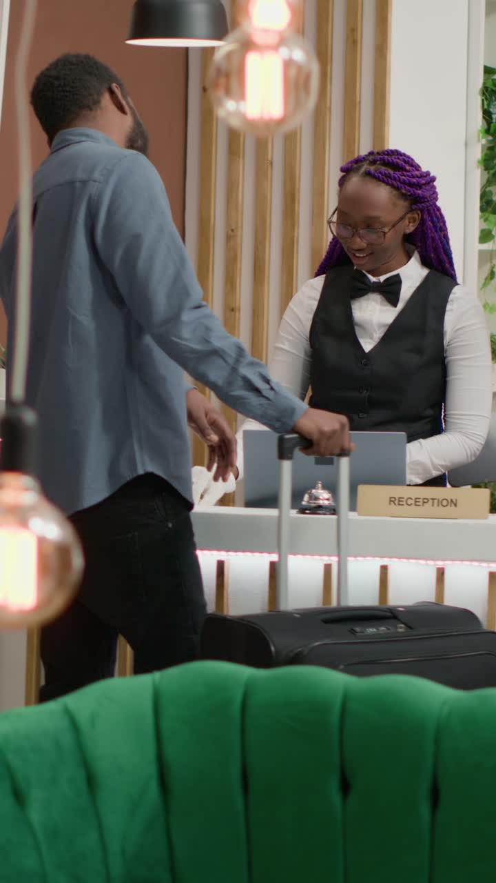 Video verticale di un viaggiatore che effettua il check-in alla reception